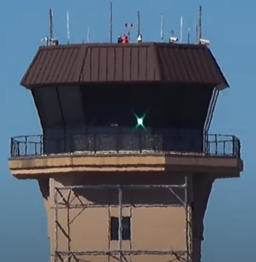 a steady green light gun signal from an airport control tower