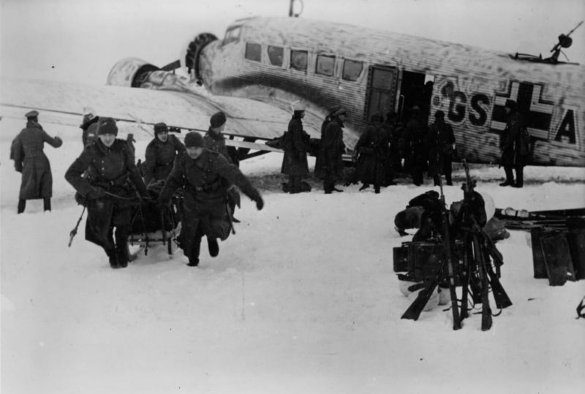 russian soldiers offload men and equipment from a ju 52 in Demyansk Fortress